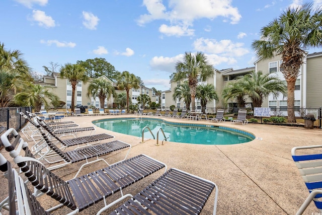 community pool featuring a patio area and fence