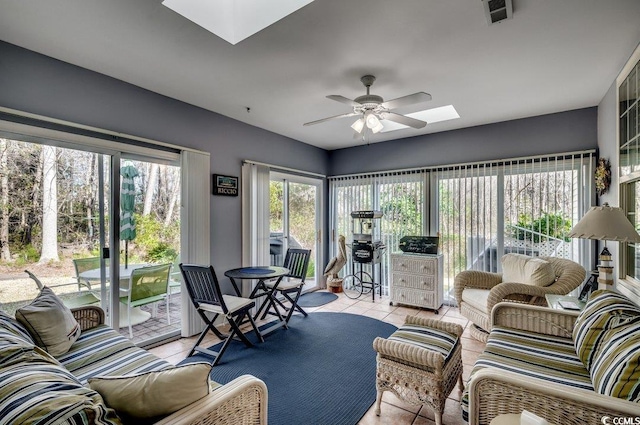 tiled living room featuring ceiling fan and a skylight