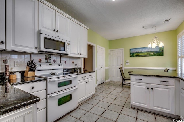 kitchen with white appliances, white cabinets, a chandelier, pendant lighting, and light tile patterned floors