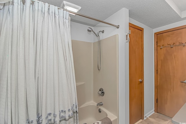 full bathroom featuring shower / bath combination with curtain, a closet, visible vents, and a textured ceiling