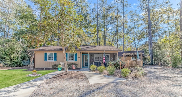 single story home featuring a front lawn and a sunroom