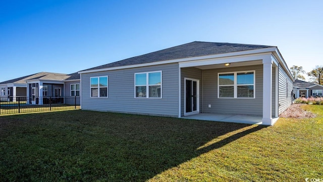 back of property with a patio and a yard