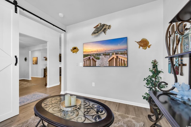 foyer featuring a barn door, baseboards, and wood finished floors