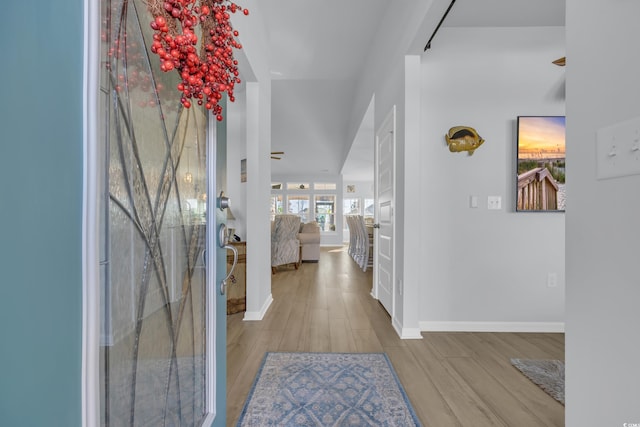 entryway with baseboards and wood finished floors