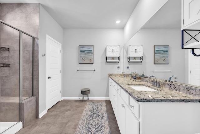 bathroom featuring baseboards, double vanity, recessed lighting, a stall shower, and a sink