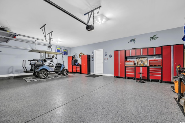 garage with a garage door opener and baseboards