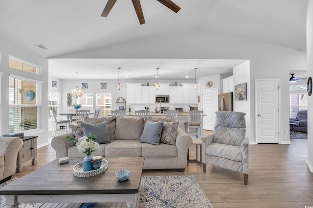 living room featuring baseboards, visible vents, light wood finished floors, and ceiling fan