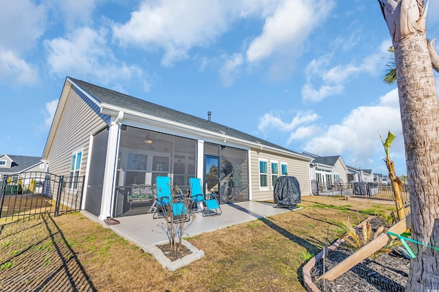 back of property with a yard, a patio, a fenced backyard, and a sunroom