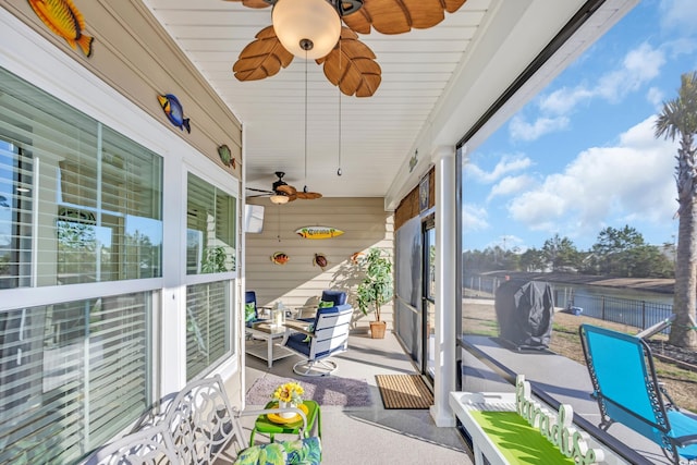 sunroom / solarium featuring a ceiling fan