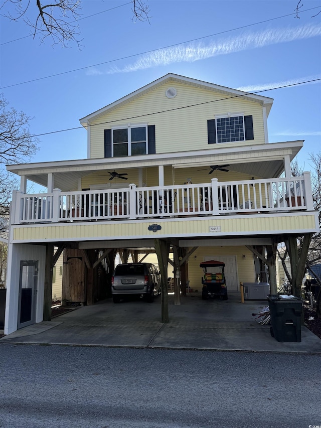 raised beach house featuring ceiling fan, a carport, and aphalt driveway