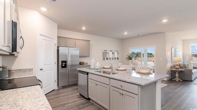 kitchen featuring a center island with sink, appliances with stainless steel finishes, sink, gray cabinetry, and dark wood-type flooring