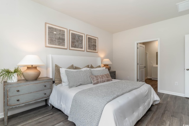 bedroom featuring ensuite bath, baseboards, visible vents, and dark wood finished floors