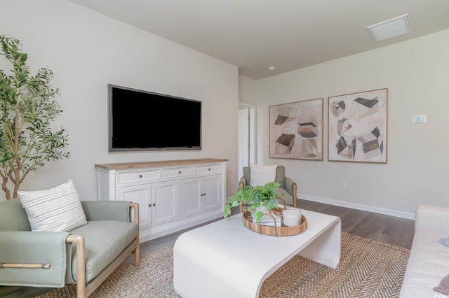 living room featuring wood finished floors, visible vents, and baseboards