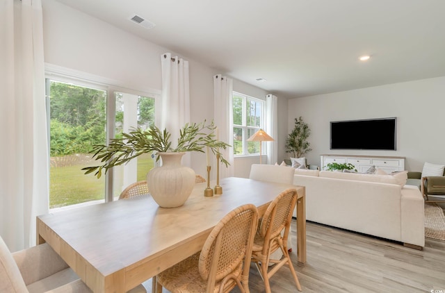 dining space with light wood-type flooring, visible vents, and recessed lighting