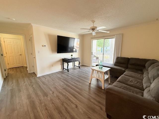 living room with hardwood / wood-style flooring, ceiling fan, crown molding, and a textured ceiling