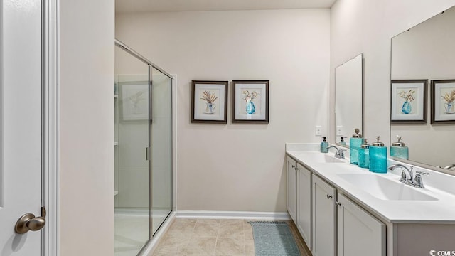 bathroom with a sink, tile patterned flooring, a shower stall, and double vanity