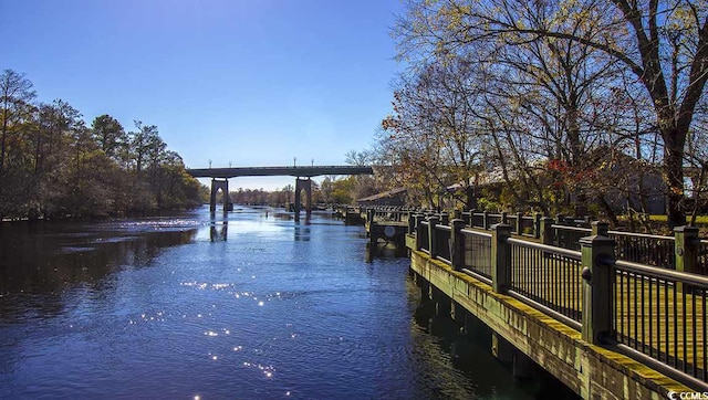 dock area with fence and a water view