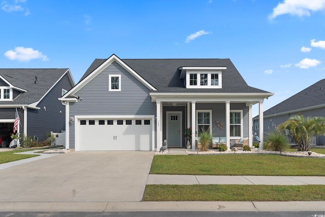 view of front of home with a garage, a front lawn, and a porch