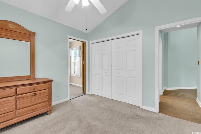 bedroom with a closet, vaulted ceiling, light colored carpet, and ceiling fan