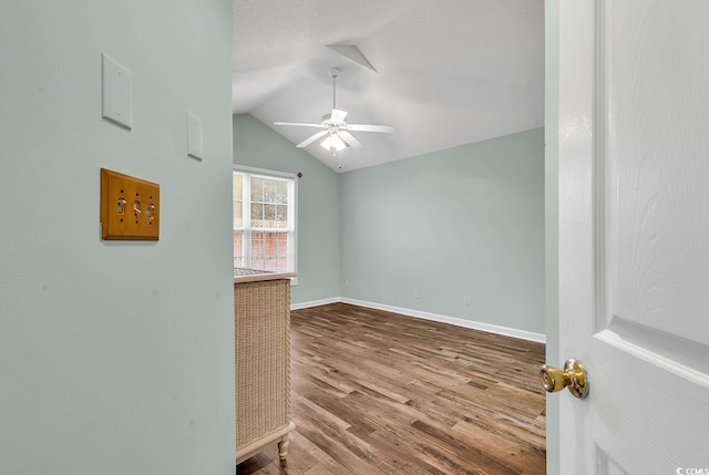 unfurnished room with hardwood / wood-style flooring, ceiling fan, and vaulted ceiling