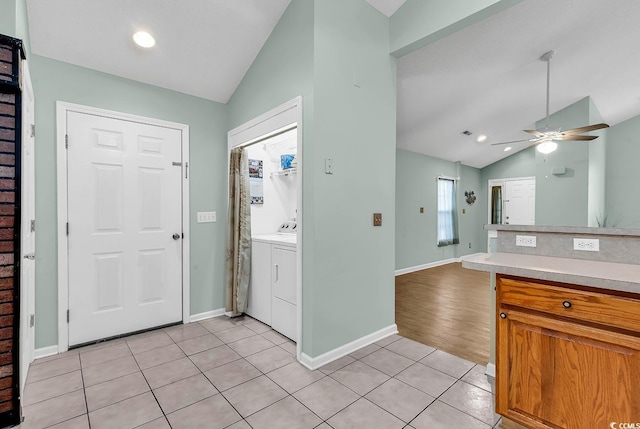 foyer featuring washer and dryer, lofted ceiling, ceiling fan, and light tile patterned floors