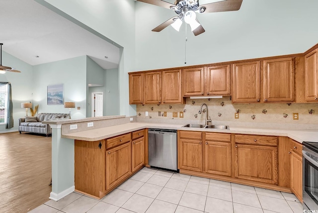 kitchen featuring kitchen peninsula, sink, stainless steel dishwasher, ceiling fan, and high vaulted ceiling