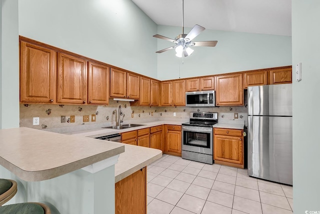 kitchen featuring a breakfast bar area, stainless steel appliances, ceiling fan, sink, and kitchen peninsula