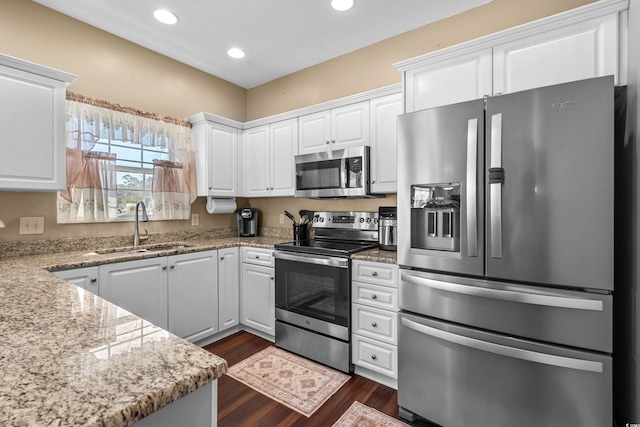 118 Gully Branch Ln Unit 3, Myrtle Beach, SC 29572 - kitchen with light stone counters, dark wood-type flooring, a sink, white cabinets, and appliances with stainless steel finishes