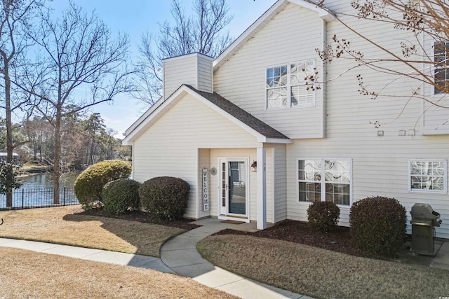 view of front of home featuring a shingled roof and fence