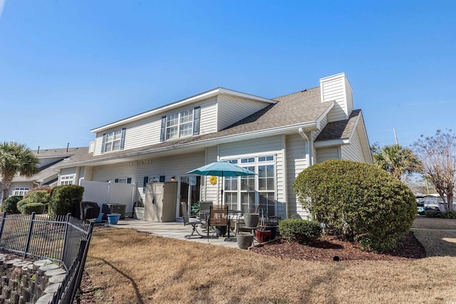 118 Gully Branch Ln Unit 3, Myrtle Beach, SC 29572 - back of house with roof with shingles, a patio, a chimney, a lawn, and fence