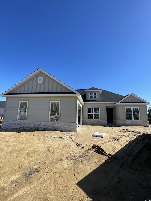 back of house featuring board and batten siding and a shingled roof