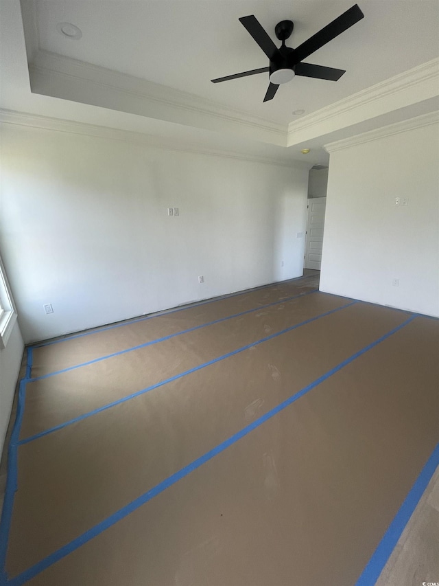 unfurnished room featuring a raised ceiling, crown molding, and ceiling fan