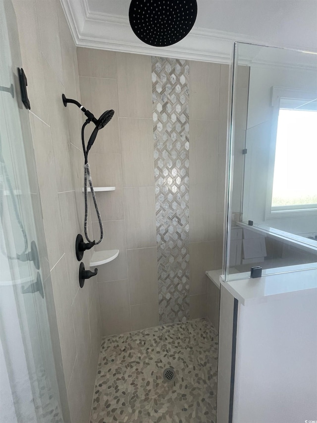 bathroom featuring ornamental molding and tiled shower