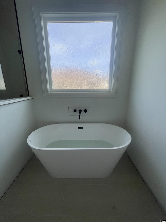 full bathroom featuring a soaking tub and tile patterned flooring