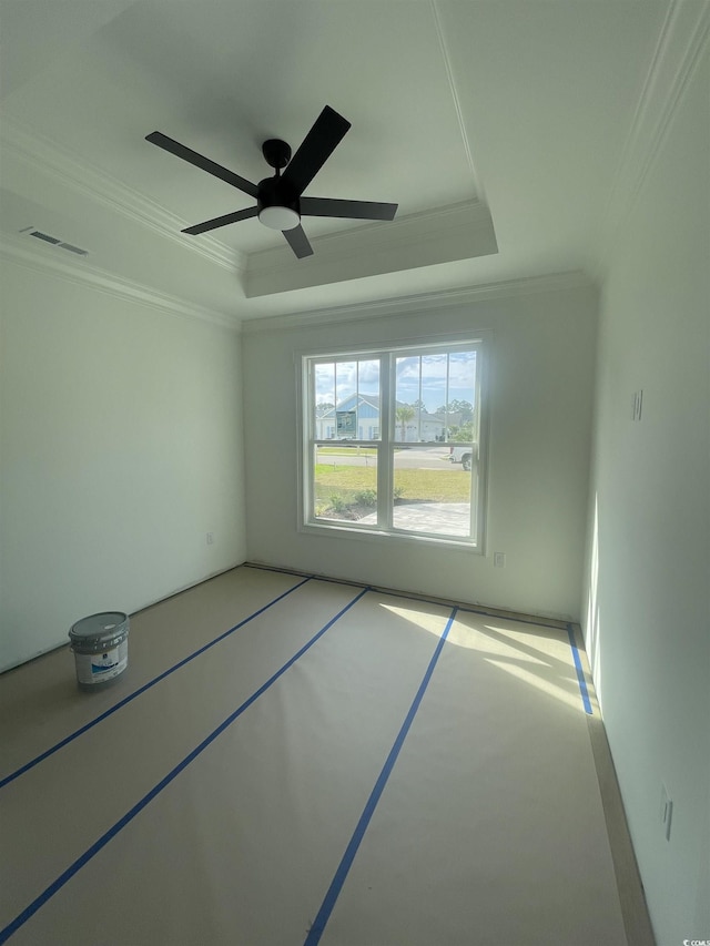 spare room featuring a tray ceiling, crown molding, and a ceiling fan