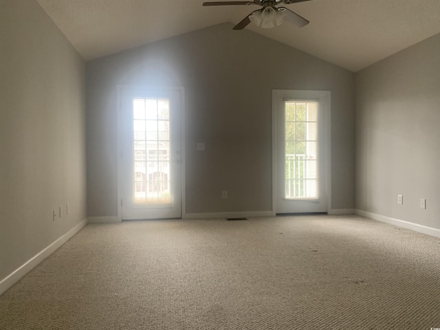 unfurnished room with vaulted ceiling, ceiling fan, and light colored carpet