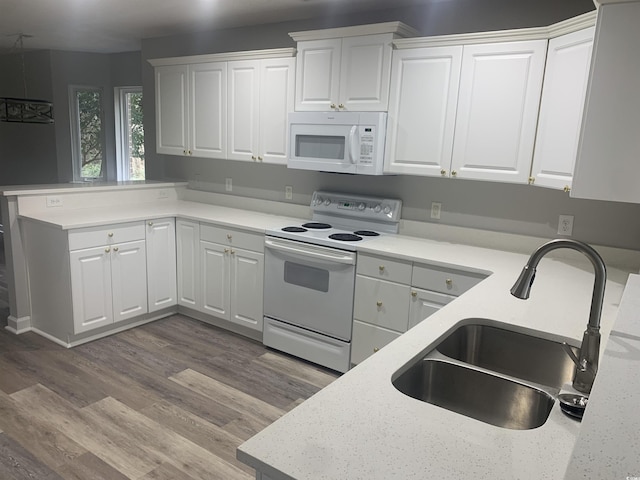 kitchen with sink, white appliances, white cabinets, and light hardwood / wood-style floors