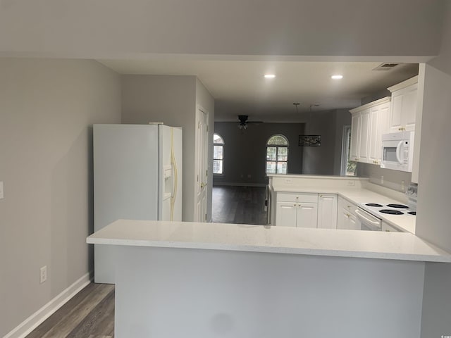 kitchen with kitchen peninsula, dark hardwood / wood-style flooring, white appliances, ceiling fan, and white cabinets