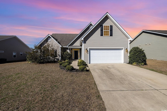 view of property with a garage and a lawn