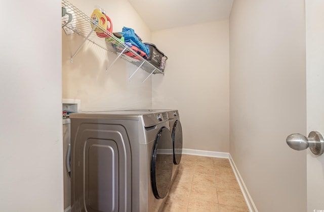 washroom featuring light tile patterned floors and washer and clothes dryer