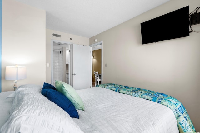 bedroom with a textured ceiling and ensuite bathroom