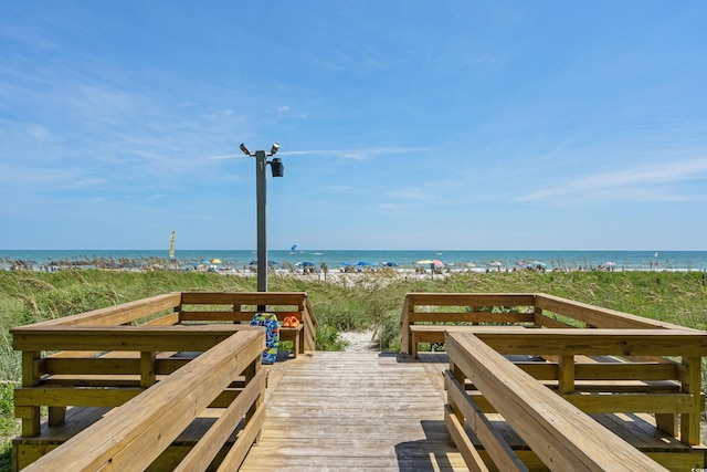 view of property's community featuring a water view and a beach view