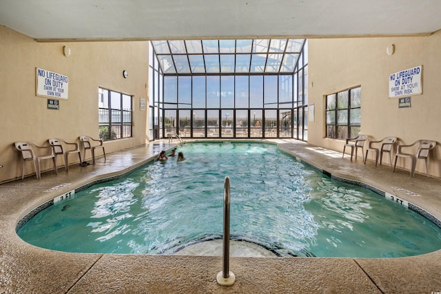 view of swimming pool with a patio area and glass enclosure