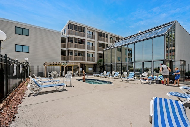 view of pool with a patio, a lanai, and a community hot tub