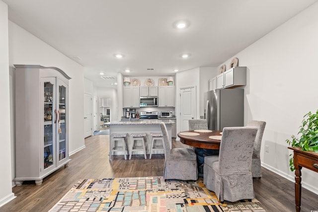 dining area with baseboards, a toaster, dark wood-type flooring, and recessed lighting