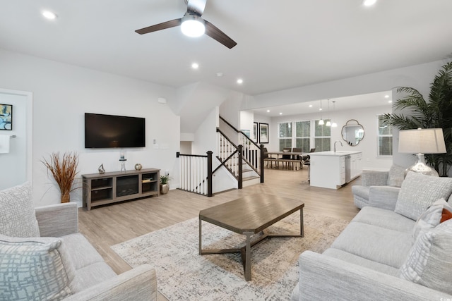 living room with light hardwood / wood-style floors, sink, and ceiling fan