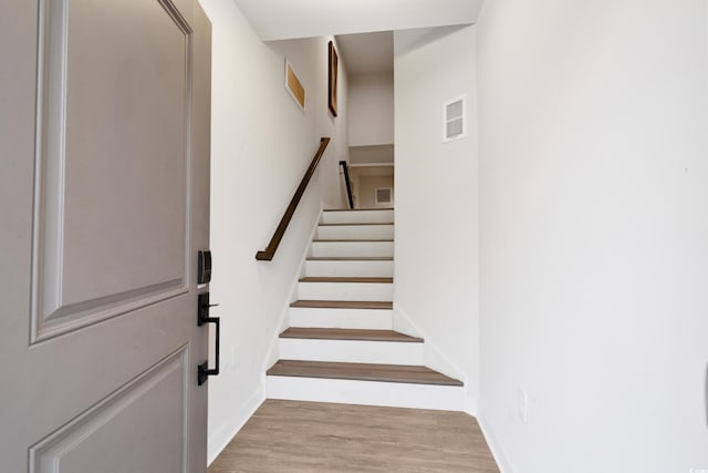 stairs featuring hardwood / wood-style floors