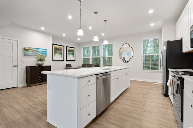 kitchen with an island with sink, white cabinetry, range with electric stovetop, sink, and stainless steel dishwasher