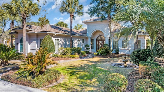 mediterranean / spanish house with french doors and a front yard