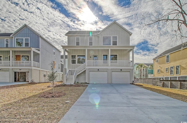 view of front of house with board and batten siding, concrete driveway, fence, and a garage